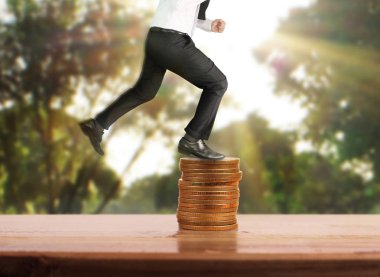 İşadamı, başarı ve yatırımı artıran madeni paraların üzerinde yürüyor