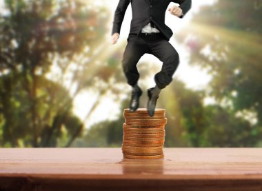 İşadamı yürümek sikkelerin yığın üzerinde başarı yetişen 