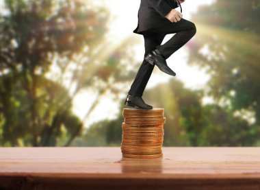 İşadamı yürümek sikkelerin yığın üzerinde başarı yetişen 