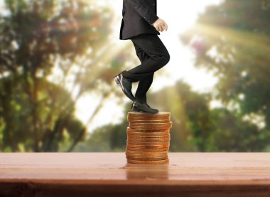 İşadamı yürümek sikkelerin yığın üzerinde başarı yetişen 