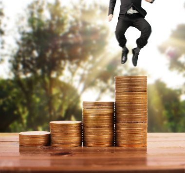 İşadamı yürümek sikkelerin yığın üzerinde başarı yetişen 