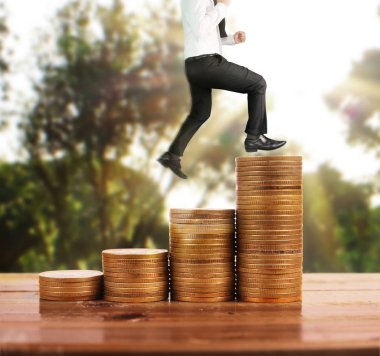 İşadamı yürümek sikkelerin yığın üzerinde başarı yetişen 