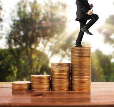 İşadamı yürümek sikkelerin yığın üzerinde başarı yetişen 