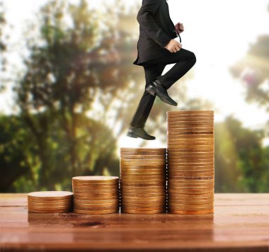 İşadamı, başarı ve yatırımı artıran madeni paraların üzerinde yürüyor