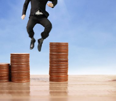 İşadamı yürümek sikkelerin yığın üzerinde başarı yetişen 