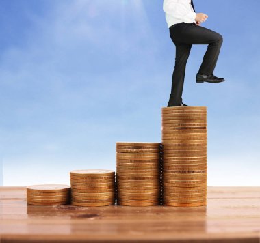 İşadamı yürümek sikkelerin yığın üzerinde başarı yetişen 