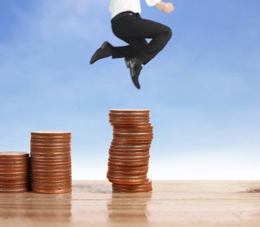 İşadamı yürümek sikkelerin yığın üzerinde başarı yetişen 