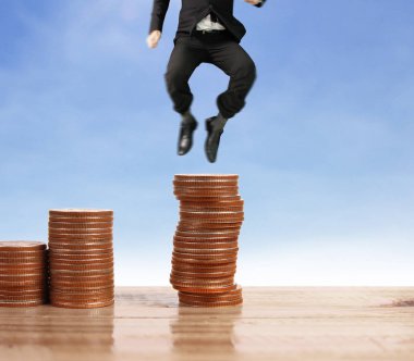 İşadamı yürümek sikkelerin yığın üzerinde başarı yetişen 