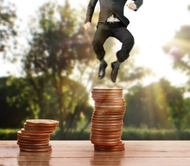 İşadamı yürümek sikkelerin yığın üzerinde başarı yetişen 