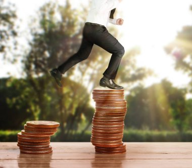 İşadamı yürümek sikkelerin yığın üzerinde başarı yetişen 