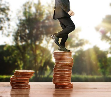 İşadamı yürümek sikkelerin yığın üzerinde başarı yetişen 