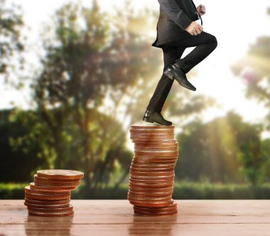 İşadamı, başarı ve yatırımı artıran madeni paraların üzerinde yürüyor