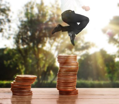 İşadamı yürümek sikkelerin yığın üzerinde başarı yetişen 