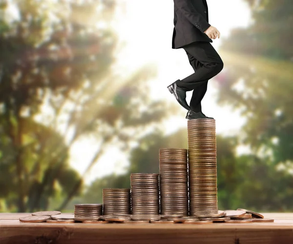 İşadamı, başarı ve yatırımı artıran madeni paraların üzerinde yürüyor