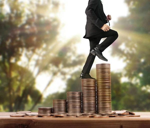 İşadamı, başarı ve yatırımı artıran madeni paraların üzerinde yürüyor