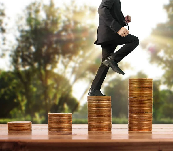 İşadamı yürümek sikkelerin yığın üzerinde başarı yetişen 