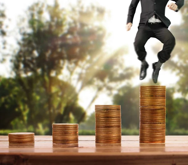 İşadamı, başarı ve yatırımı artıran madeni paraların üzerinde yürüyor