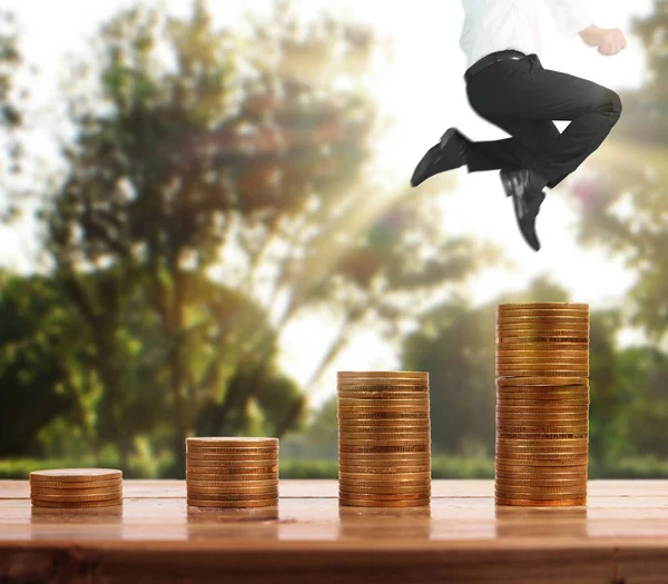 İşadamı, başarı ve yatırımı artıran madeni paraların üzerinde yürüyor