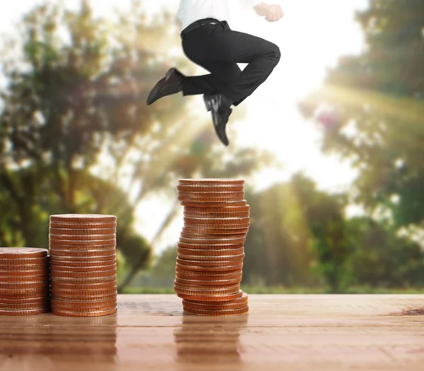 İşadamı, başarı ve yatırımı artıran madeni paraların üzerinde yürüyor