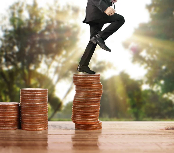 İşadamı, başarı ve yatırımı artıran madeni paraların üzerinde yürüyor