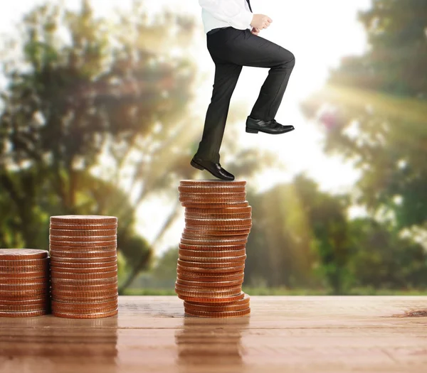 İşadamı, başarı ve yatırımı artıran madeni paraların üzerinde yürüyor