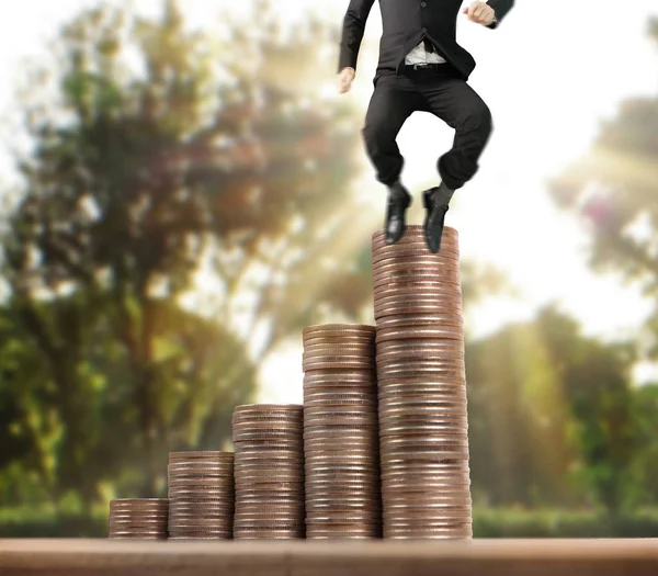 İşadamı, başarı ve yatırımı artıran madeni paraların üzerinde yürüyor