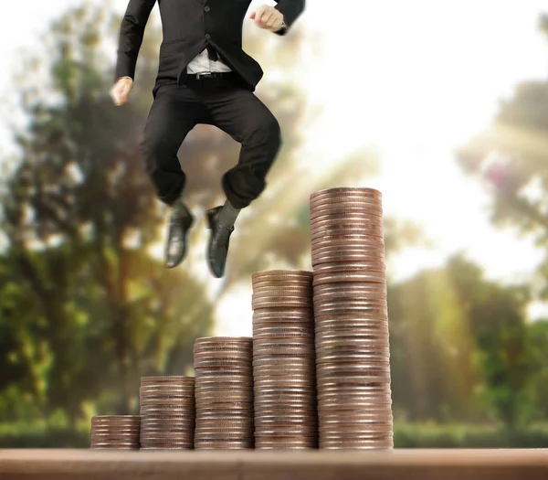 İşadamı, başarı ve yatırımı artıran madeni paraların üzerinde yürüyor