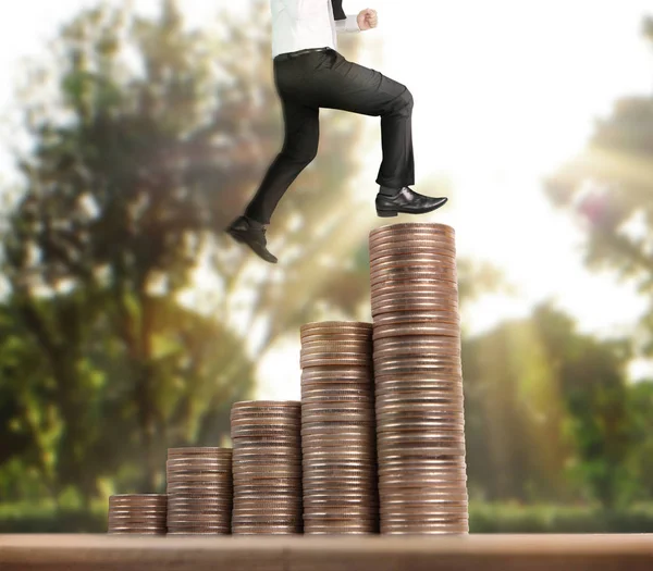 Businessman walk on stack of coins which grows success — Stock Photo, Image