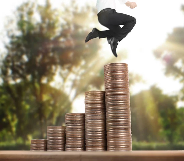 İşadamı yürümek sikkelerin yığın üzerinde başarı yetişen 