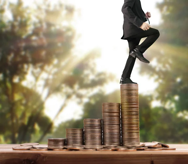 İşadamı yürümek sikkelerin yığın üzerinde başarı yetişen 