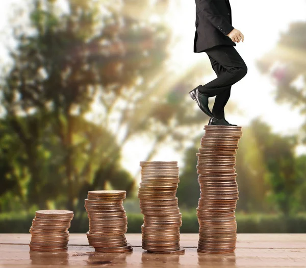 İşadamı, başarı ve yatırımı artıran madeni paraların üzerinde yürüyor