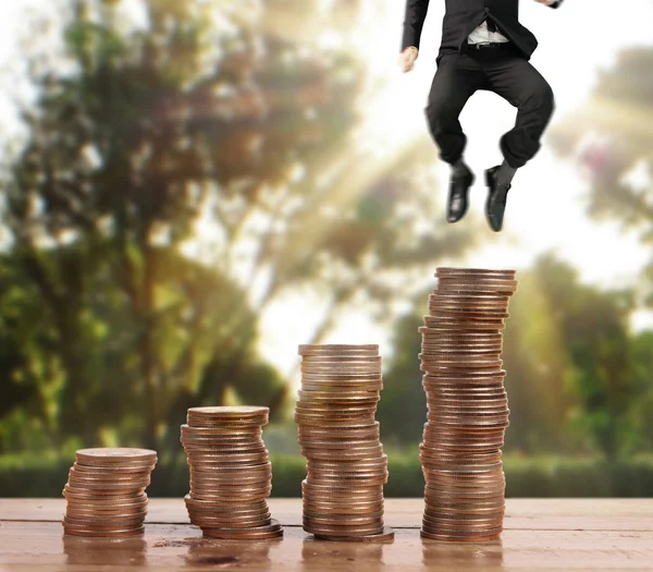 İşadamı, başarı ve yatırımı artıran madeni paraların üzerinde yürüyor