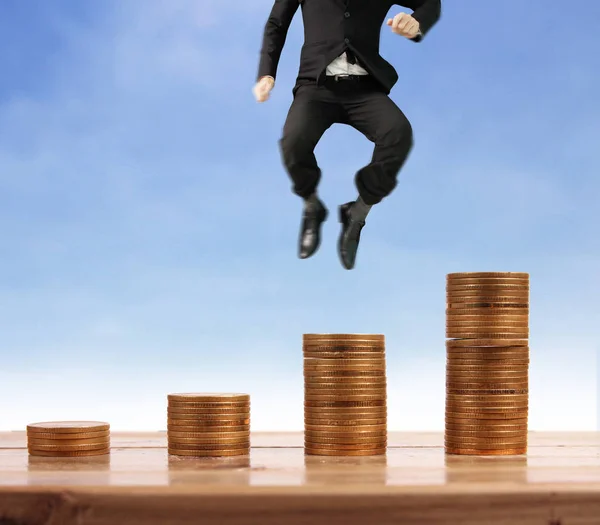 Бізнесмен ходить по стопах монет, які ростуть успішно — стокове фото