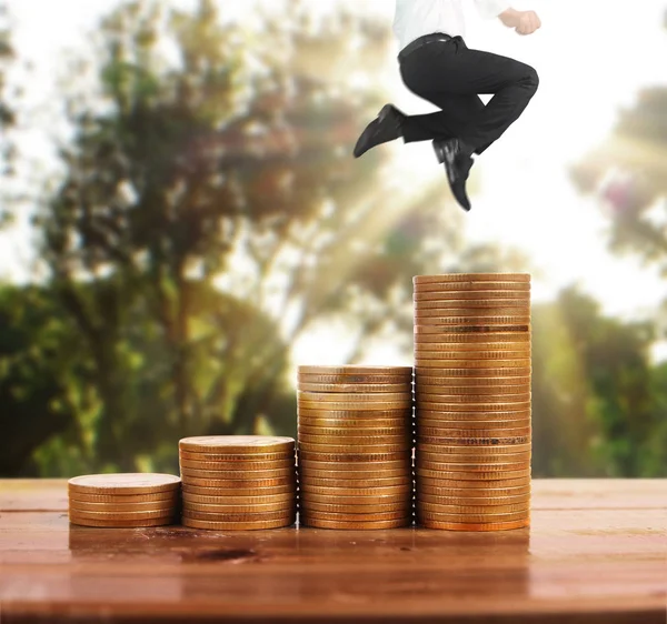 İşadamı, başarı ve yatırımı artıran madeni paraların üzerinde yürüyor