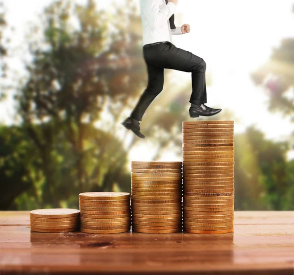 İşadamı yürümek sikkelerin yığın üzerinde başarı yetişen 