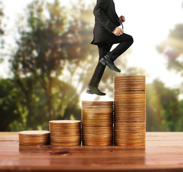 İşadamı, başarı ve yatırımı artıran madeni paraların üzerinde yürüyor