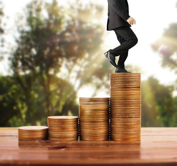 İşadamı, başarı ve yatırımı artıran madeni paraların üzerinde yürüyor