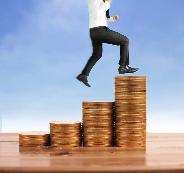 İşadamı yürümek sikkelerin yığın üzerinde başarı yetişen 