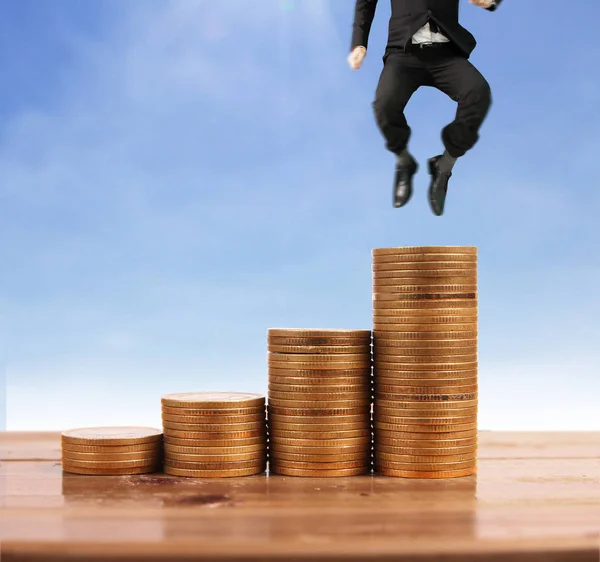 İşadamı yürümek sikkelerin yığın üzerinde başarı yetişen 