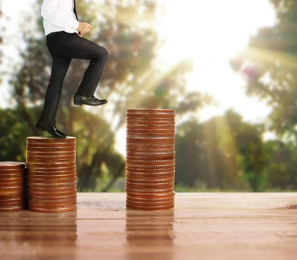 İşadamı yürümek sikkelerin yığın üzerinde başarı yetişen 