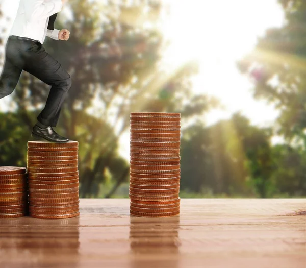 İşadamı, başarı ve yatırımı artıran madeni paraların üzerinde yürüyor