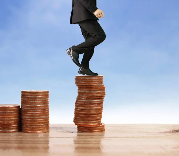 Businessman walk on stack of coins which grows success — Stock Photo, Image