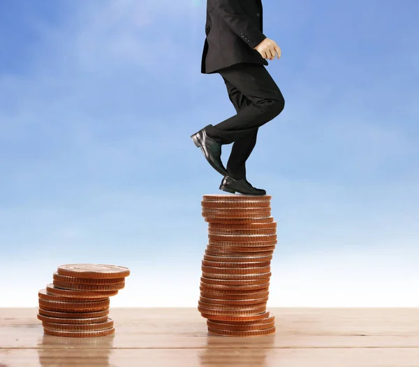 Businessman walk on stack of coins which grows success — Stock Photo, Image