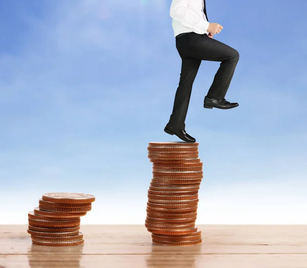 Businessman walk on stack of coins which grows success — Stock Photo, Image