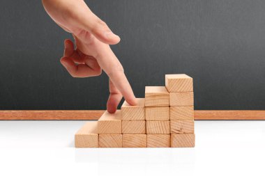 Oyuncak merdivenlere tırmanan el yapımı iş adamı.