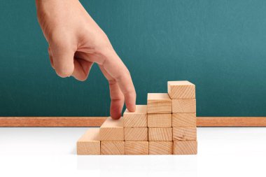 Oyuncak merdivenlere tırmanan el yapımı iş adamı.