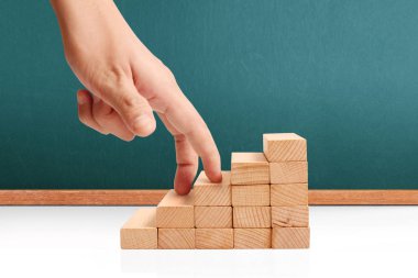 Oyuncak merdivenlere tırmanan el yapımı iş adamı.