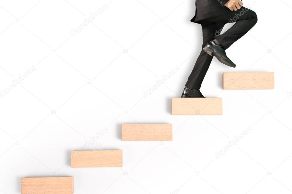business person stepping up a toy staircase