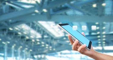 Bir tablet tutan eller bilgisayarlara dokunur.