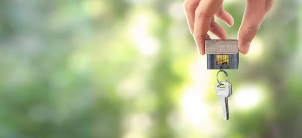 Immobilienmakler übergibt Hausschlüssel in der Hand — Stockfoto